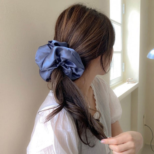 Woman wearing a blue satin French Hair Clips and Barrettes scrunchie in her hair.